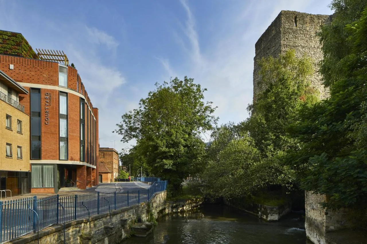 a river next to a building and a castle at Courtyard by Marriott Oxford City Centre in Oxford