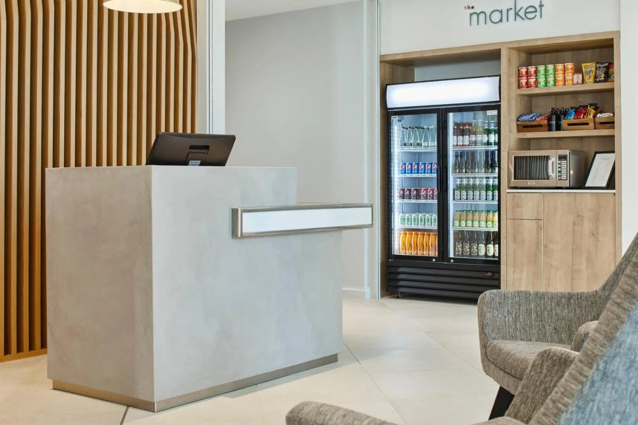a lobby with a cash register and two chairs at Courtyard by Marriott Oxford City Centre in Oxford